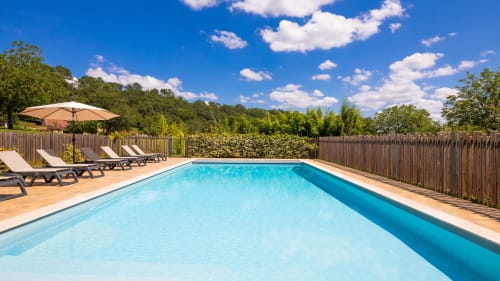 Domaine De Campagnac resort pool in Carsac-Aillac with loungers, umbrella, and garden views