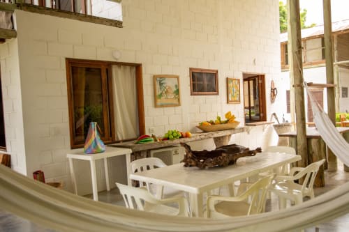 Terraza de la villa Olamar Living en Santiago de Tolú con mesa de comedor, sillas blancas y acceso a vista al mar
