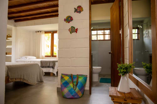 Dormitorio y baño coloridos en villa de Olamar Living en Santiago de Tolú, con decoración tropical y comodidades modernas
