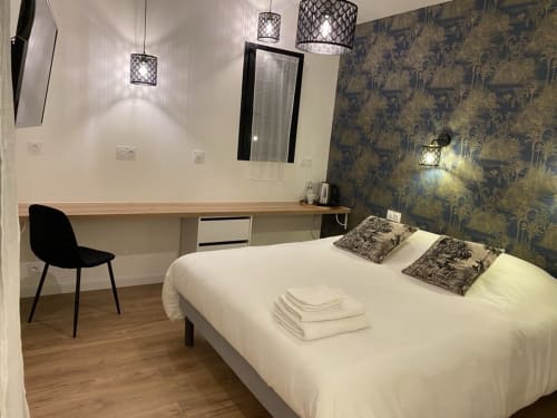 Moderna camera doppia a La Maison Blanche a Bouguenais con scrivania, lampade a sospensione e parete accent con carta da parati decorativa.