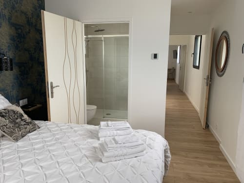 Moderna camera doppia a La Maison Blanche con bagno privato, biancheria bianca, pavimentazione in legno e arredamento contemporaneo