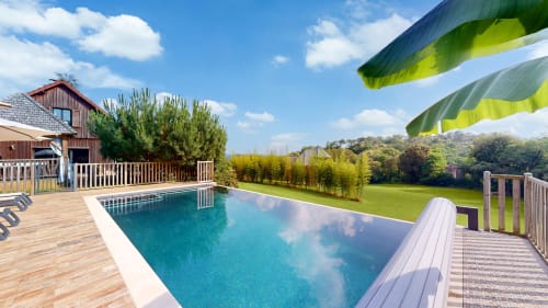 Luxe cottage op Domaine De Campagnac met glinsterzwembad, houten terras, groene luifels en uitzicht op glooiend platteland