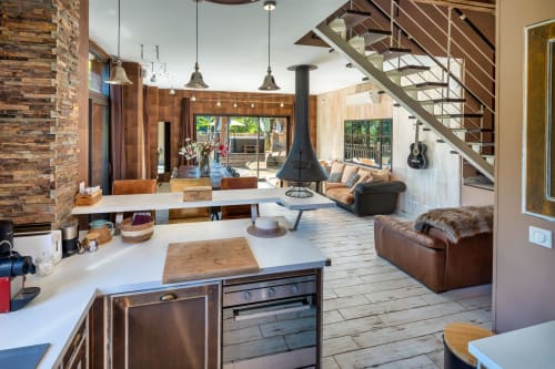 Moderne open plattegrond van cottage Domaine De Campagnac met keuken, houtkachel, lederen zitplaatsen en deuren naar het zwembad