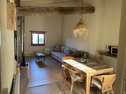 Habitación L'Isard en Casa Tapiolas con comedor, vigas rústicas, sofá y vistas a las montañas en Molló