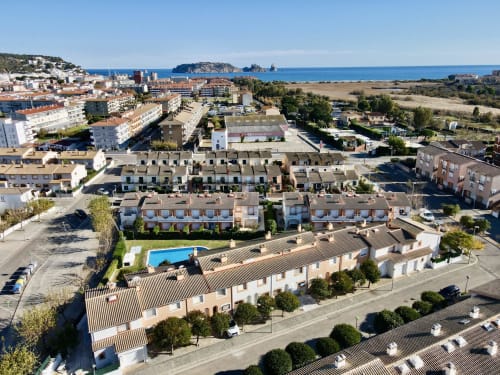 Vista aérea de los cottages de alquiler Estartit con piscina, mar Mediterráneo e islas Medes al fondo