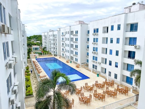 Complejo residencial Olamar en Coveñas con piscina azul, palmeras y edificios modernos blancos con detalles azules