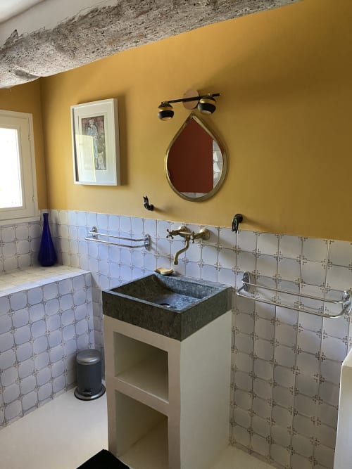 Salle de bain moderne de l'Appartement Bambou au Mas du Fort, Gargas, avec vasque en pierre, robinetterie en laiton et murs jaunes