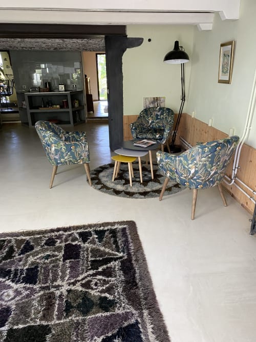 Coin salon confortable de l'Appartement Bambou au Mas du Fort avec fauteuils à motifs, lampadaire noir et décoration moderne