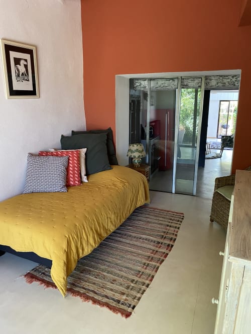 Chambre lumineuse de l'Appartement Bambou au Mas du Fort, Gargas, avec lit jaune et armoire miroir