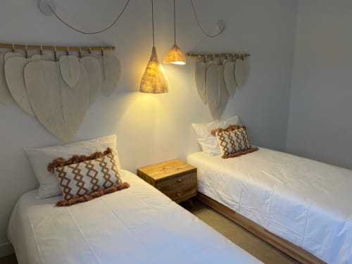 Camas gêmeas com almofadas decorativas, luminárias suspensos e parede com folhas secas na villa Casa Furnas do Star Host, Bordeira