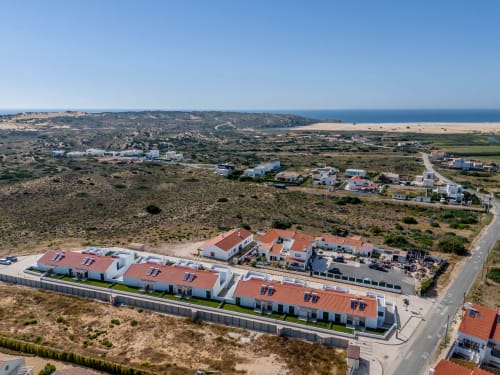 Vista aérea das vilas Star Host em Bordeira, Portugal com vistas de mar, paisagem costeira e arquitetura moderna