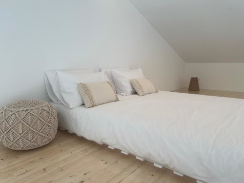 Quarto espaçoso da villa Casa Zavial com roupa de cama branca, almofadas creme e piso em madeira em Bordeira
