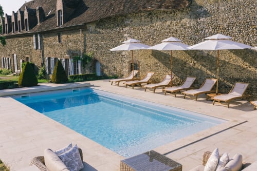 Piscine du Prieuré du Preux avec chalet en pierre, transats et parasols à Sépeaux Saint Romain, France