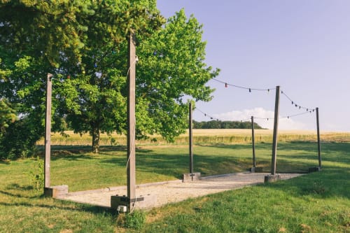 Espace de jardin extérieur du gîte Le Prieuré Du Preux à Sépeaux Saint Romain avec poteaux en bois, guirlandes lumineuses et ambiance champêtre