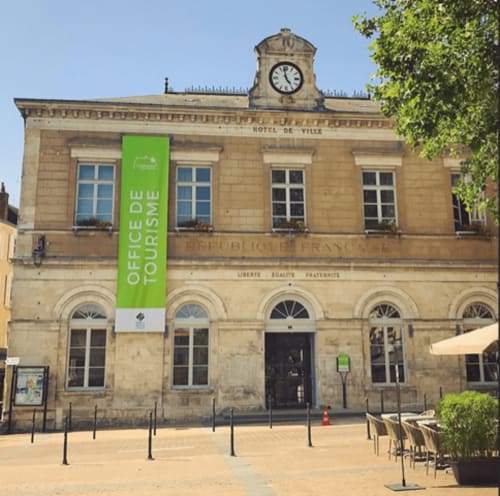 Bâtiment historique de l'Hôtel de Ville à Châteauroux avec bannière de tourisme vert et tour d'horloge