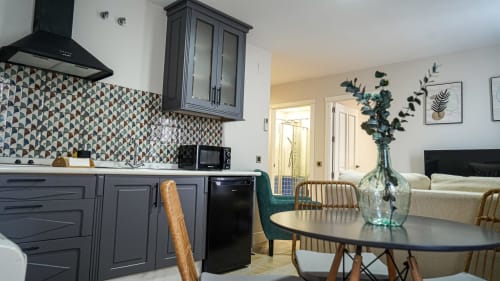Cocina y comedor moderno en Mérida con backsplash estampado, gabinetes oscuros y mesa redonda