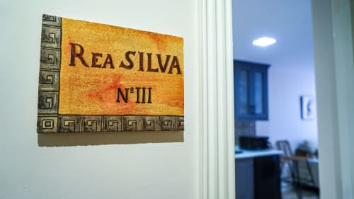 Placa del apartamento Rea Silva No. III en el hotel Gestyp-AT de Mérida, España con borde decorativo de greca griega