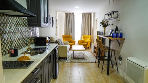 Moderno apartamento en Mérida con cocina, sillones amarillos y sala con vistas a monumentos