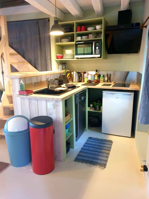 Petite kitchenette moderne à La Dragonne B&B à Bellême avec étagères vert anis, évier, micro-ondes et réfrigérateur blanc