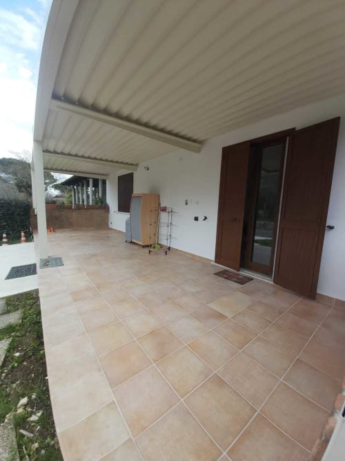 Patio coperto con pavimento in cotto e porte in legno scuro presso l'appartamento DAF HOUSE a Roccasecca, Italia