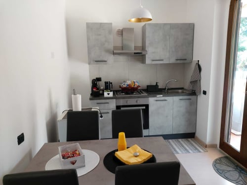 Cucina moderna con mobili grigi e zona pranzo nell'appartamento DAF House a Roccasecca, Italia
