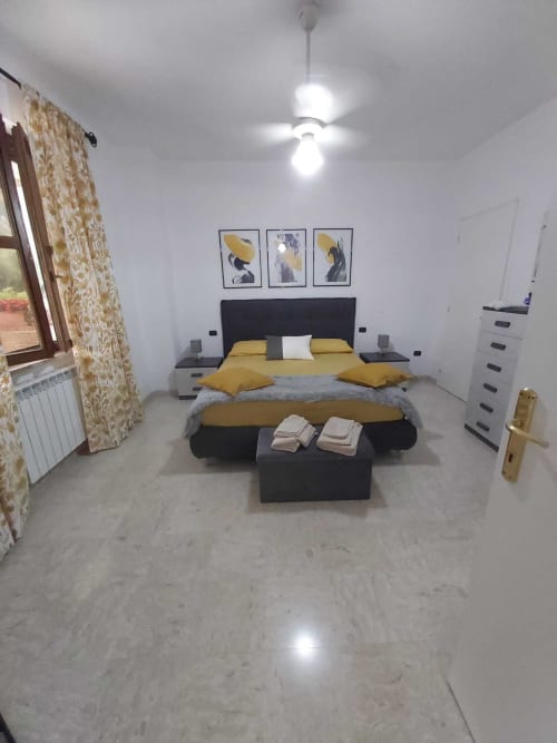 Camera moderna di DAF HOUSE a Roccasecca con biancheria gialla, testata nera e vista sulle montagne