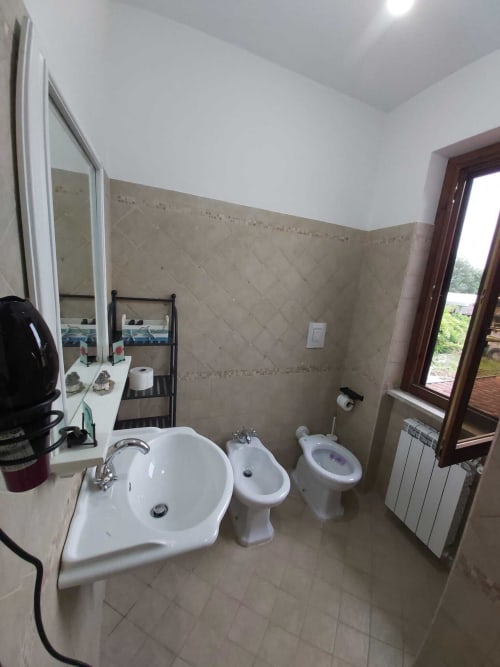 Bagno dell'appartamento DAF HOUSE a Roccasecca con lavabo, bidet, toilette e specchio