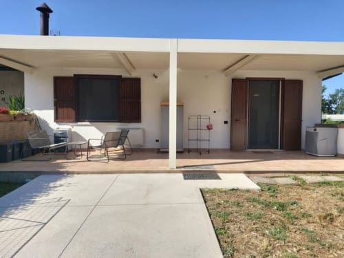 Terrazza DAF House Roccasecca con aree salotto coperte, lettini e porte in legno scuro