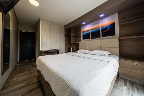 Habitació Deluxe moderna a l'Hôtel Rocade Pamiers amb llit queen-size, xapa de fusta, obra d'art posta de sol i mobiliari contemporani