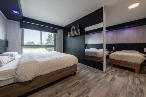 Habitació familiar moderna a l'Hôtel Rocade de Pamiers amb llit, armari amb mirall, parets negres i vistes a la ciutat