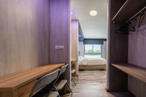 Sala familiar moderna a l'Hôtel Rocade de Pamiers amb zona de treball i vista al dormitori amb finestres a la ciutat