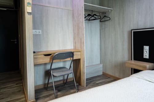 Habitació superior de l'Hôtel Rocade a Pamiers amb escriptori de fusta, cadira, llit i serveis moderns