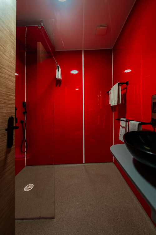 Mampara de dutxa moderna roja amb griferia negra a l'Hôtel Rocade de Pamiers, França