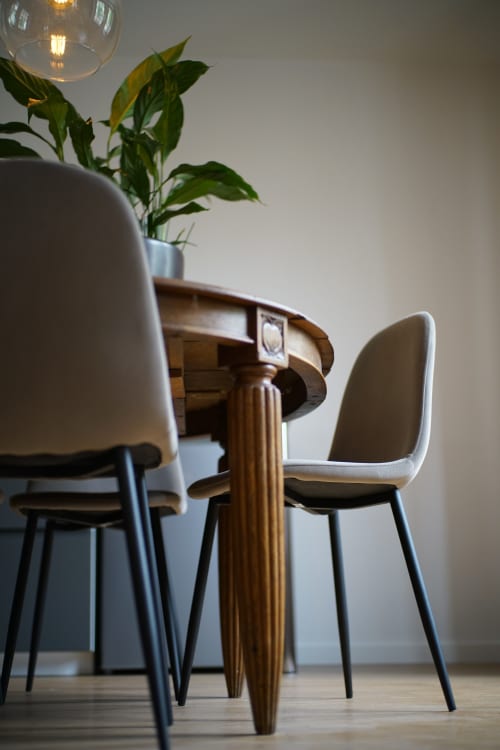 Salle à manger moderne aux Gîtes bo à Saint-Romain avec table ronde en bois, chaises crème, suspension et plante en pot
