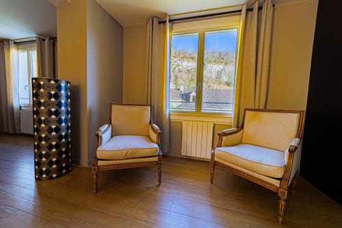 Yellow guest room with two armchairs at Gites bo, Saint-Romain, France, featuring wooden floors and mountain views