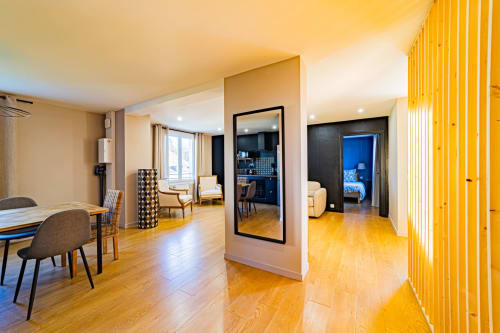 Modern open-plan apartment at Gites bo in Saint-Romain with wooden floors, dining area, and bright yellow accents