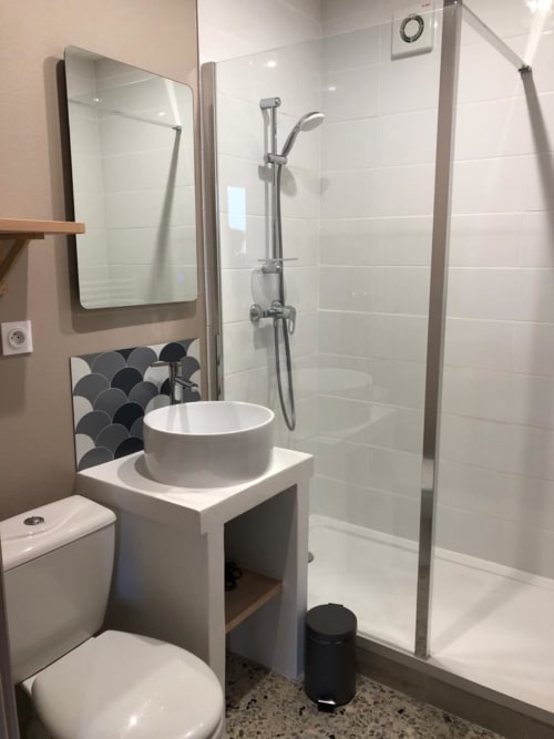 Modern bathroom at Gites bo B&B in Saint-Romain with glass shower, round sink, and heated towel rail