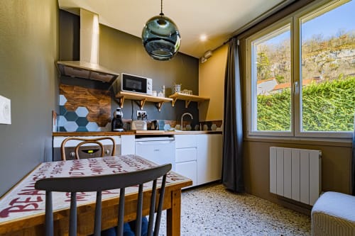 Modern kitchen-dining area at Gites bo BnB in Saint-Romain with yellow walls, dining table, and garden views
