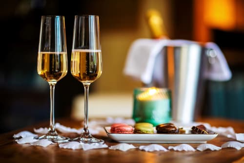 Two champagne flutes with macarons and chocolates at Domaine De Campagnac, a French bed and breakfast in Carsac-Aillac