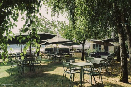 Outdoor patio with tables and black umbrellas at Domaine de l'Oie Rouge, a bed and breakfast near Gennes-Val-de-Loire