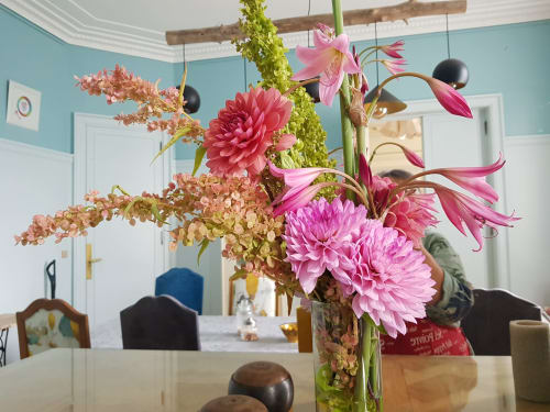 Vibrant floral arrangement with pink dahlias and orchids in a dining room at Domaine de l'Oie Rouge, Loire Valley