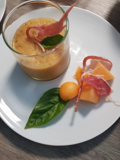 Elegant gourmet appetizer with apricot mousse cocktail, prosciutto, and melon at Domaine de l'Oie Rouge, Loire Valley.