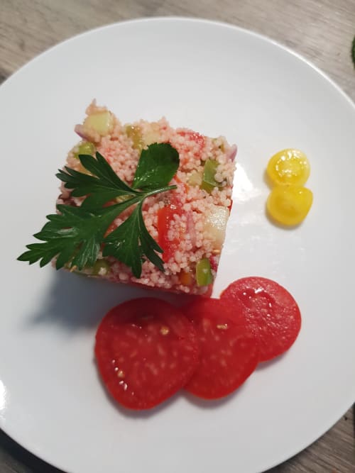 Fine dining plated dish with pink seafood risotto, fresh tomato slices, and edible flowers at Domaine de l'Oie Rouge Loire
