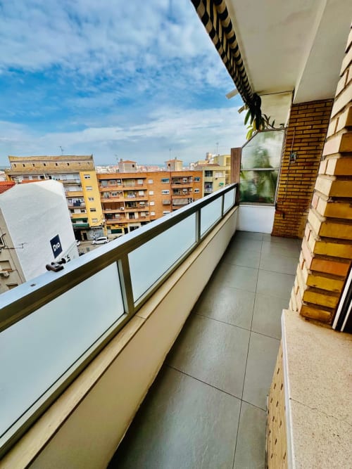 Amplio balcón con vistas a la ciudad de Mérida, apartamento del hotel Gestyp-AT con barandilla moderna y edificios circundantes