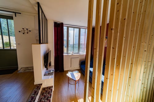 Studio moderne Le Boisé aux Gîtes bo à Saint-Romain : cloisons en bois, lit, TV et larges fenêtres lumineuses