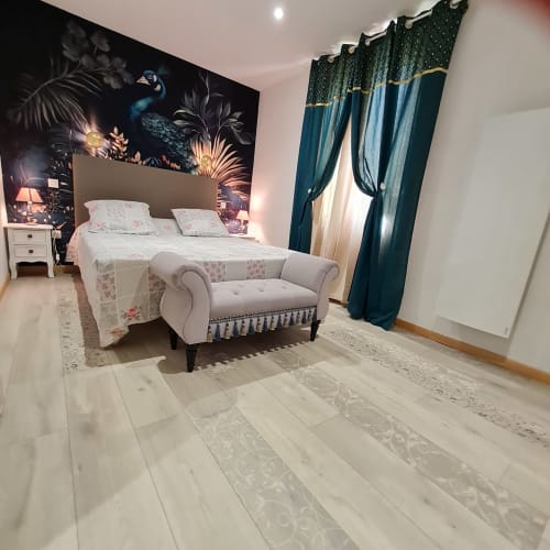 Chambre Suite Opale avec lit double, décor paon et ambiance élégante
