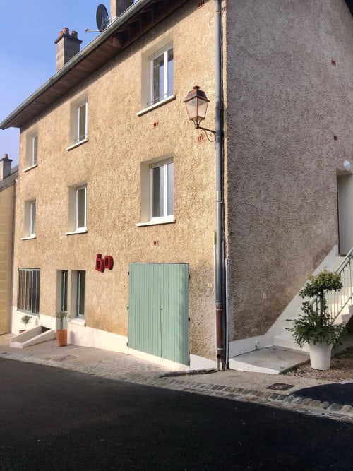 Gites bo B&B exterior in Saint-Romain, France with stone facade, green gate, and street lamp