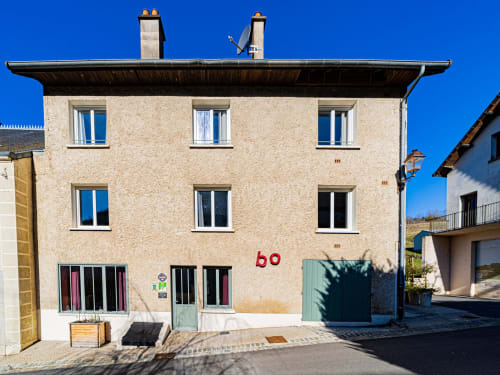 Gites bo BnB in Saint-Romain features a cream-colored stone building with blue shutters and red house number