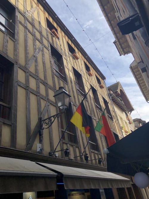 Half-timbered historic building with Romanian and French flags in Troyes, Le Paillot de Montabert hotel entrance