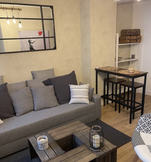 Studio moderne à l'hôtel Le Paillot de Montabert, Troyes : canapé gris, table à manger et art mural décoratif